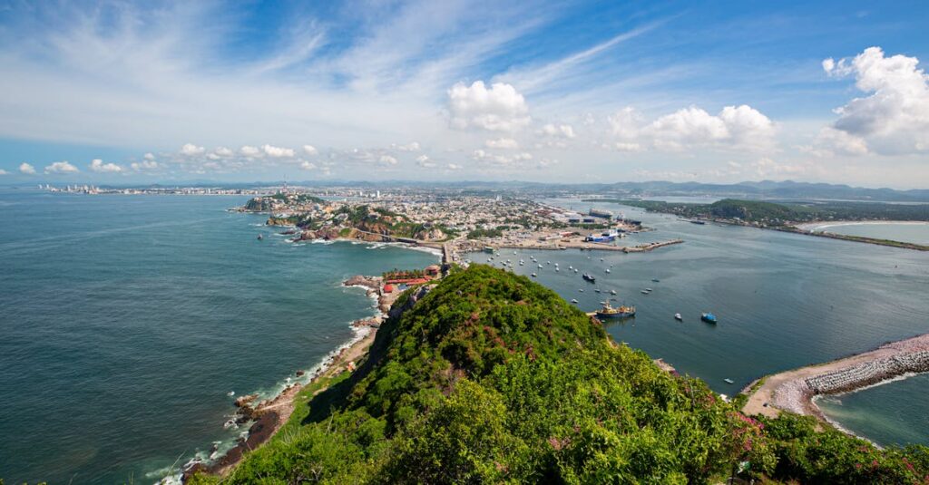 Stunning aerial view of Mazatlán's coastline, featuring the vibrant city, lush hills, and blue ocean.